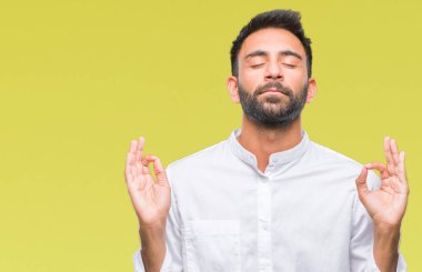 İzole arka plan yetişkin İspanyol adam rahatla ve gülümseyen gözlerle kapalı parmak jestle meditasyon yapıyor. Yoga kavramı.