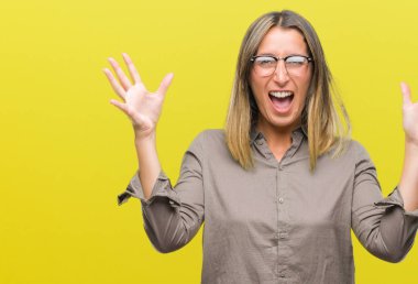 Genç güzel kadın deli kutluyor ve silah ile başarı için heyecanlı çığlık kaldırdı ve açık gözleri hayret izole arka plan yüzünden. Kazanan kavramı