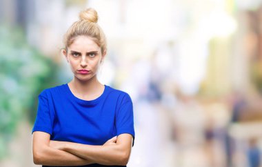 İzole arka plan şüpheci ve sinir, onaylamayan ifade yüz çapraz kolları üzerinde mavi t-shirt giyen genç güzel sarışın ve mavi gözlü kadın. Negatif kişi.