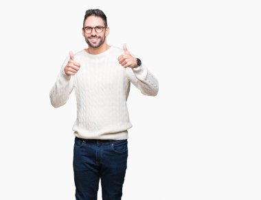 Yakışıklı delikanlı izole arka plan başarı işareti el ile pozitif jest yapıyor üzerinde gözlük takan başparmak gülümseyen ve mutlu. Neşeli bir ifadeyle, kazanan jest kameraya bakıyor.