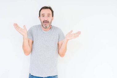 Üst düzey yakışıklı üzerinde izole arka plan clueless ve şaşkın bir ifadeyle kollar ve eller kaldırdı. Şüphe kavramı.