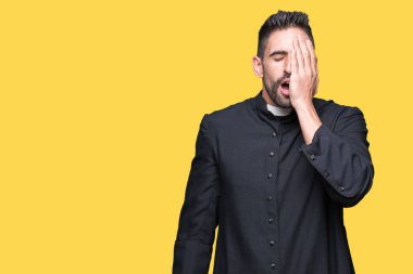 Genç Hıristiyan rahip yarım yüz, göz ve ağız el ile kapsayan Yawning yorgun izole arka plan üzerinde. Acı yüzü acıyor.