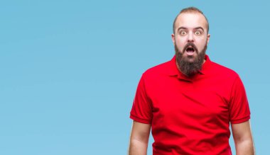 Korkuyor ve şok sürpriz ifade, korku ve heyecan yüz ile izole arka plan üzerinde kırmızı gömlek giymiş genç beyaz hipster adam.