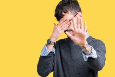 Genç yakışıklı akıllı adam elleriyle gözlerini kapsayan izole arka plan üzerinde gözlük takan ve stop jest ile acı ve korku ifadesi. Utandım ve negatif kavramı.