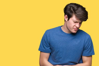 Üzerinde mavi t-shirt giyen genç yakışıklı adam izole mide üzerinde el ile arka plan çünkü hazımsızlık, ağrılı hastalık hasta hissediyor. Ağrısı kavramı.