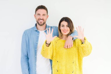 Genç güzel çift togheter gösterilen ve parmakları ile işaret izole arka plan üzerinde kendinden emin ve mutlu gülümseyerek süre on numara.