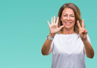 Orta yaş üst düzey İspanyol kadın gösterilen ve parmakları ile işaret izole arka plan yüzünden kendinden emin ve mutlu gülümseyerek süre yedi numara.