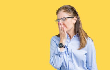 Güzel orta yaş olgun iş kadını izole arka plan üzerinde gözlük el ağzıyla kapsayan yorgun esneme sıkılmış. Restless ve uyku hali.