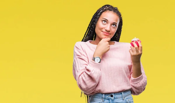 Afro Amerikaanse Meisje Cupcake Eten Geïsoleerde Achtergrond Ernstige Gezicht Denken — Stockfoto