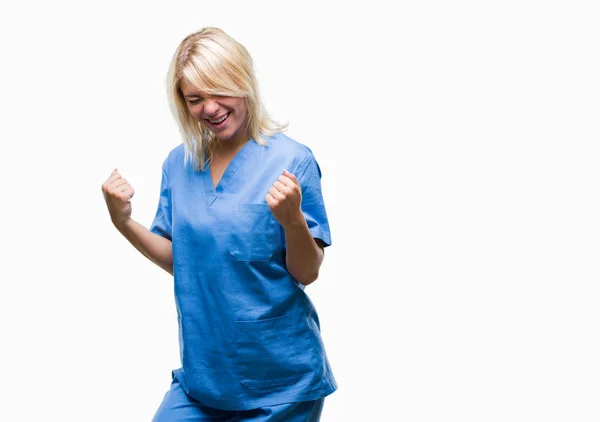 美しいブロンドの看護師医師女性非常に幸せと興奮の腕を上げ 勝者のジェスチャを行う分離の背景に 笑みを浮かべて 成功のために叫んで お祝いのコンセプト — ストック写真