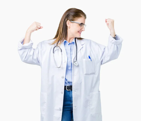 中年成熟的医生妇女穿着医疗外套在孤立的背景显示手臂肌肉微笑自豪 健身理念 — 图库照片