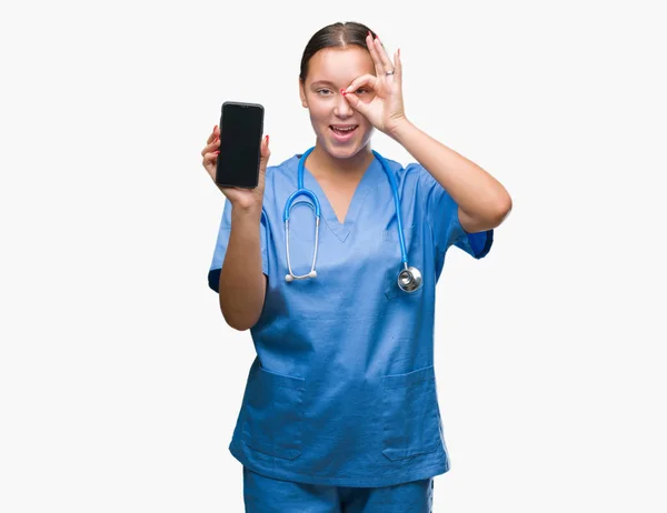 年轻的高加索医生妇女在孤立的背景显示聪明与快乐的脸微笑做确定的标志与手在眼睛上看着通过手指 — 图库照片