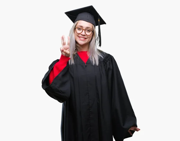 分離背景表示と指で上向きに大学院の制服を着て若いブロンドの女性数は自信を持って 幸せな笑みを浮かべている間 — ストック写真
