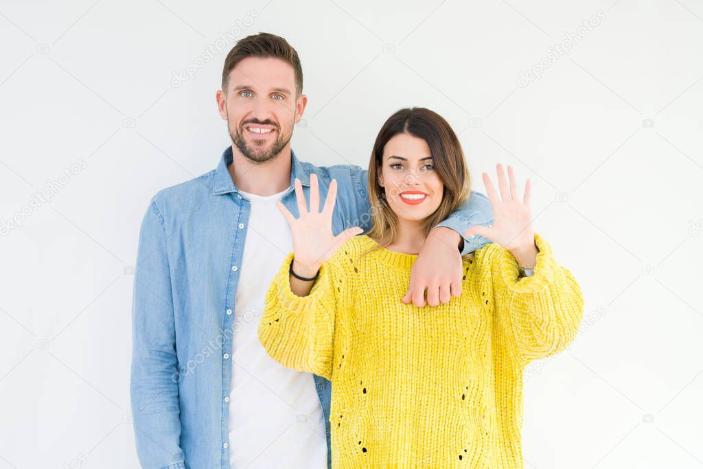 Young beautiful couple togheter over isolated background showing and pointing up with fingers number ten while smiling confident and happy.