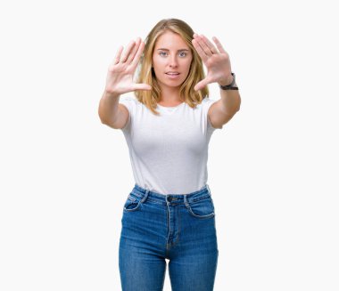 Casual beyaz t-shirt üzerinde izole giyen güzel genç kadın arka plan kullanarak el avuç içi ve parmaklar, kamera perspektif çerçevesini yapıyor gülen