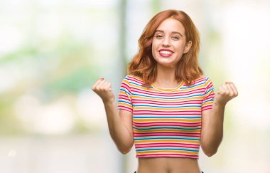 İzole arka plan kutlama üzerinde genç güzel kadın şaşırttı ve başarı için kaldırdı kollarını açarak hayret ve gözleri açık. Kazanan kavramı.