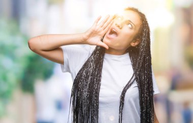 Genç örgülü saç Afro-Amerikan Kız bağırarak ve ağzı üzerinde el ile yan için çığlık izole arka plan üzerinde. İletişim kavramı.