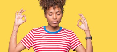 Güzel genç Afro-Amerikan kadın izole arka plan üzerinde dinlenmek ve gülümseyen gözlerle parmak ile meditasyon jest yapıyor kapalı. Yoga kavramı.