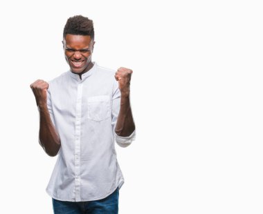 Gülümseyen ve başarı için çığlık genç Afro-Amerikan adam izole arka plan çok mutlu ve heyecanlı kaldırdı, silah ile kazanan jest yapıyor. Kutlama kavramı.