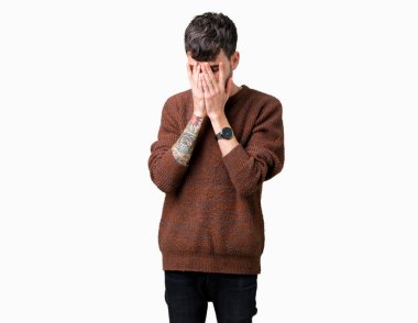 Genç yakışıklı adam üzgün ifade yüz eller ile ağlayarak süre kapsayan ile izole arka plan üzerinde kış kazak giyiyor. Depresyon kavramı.