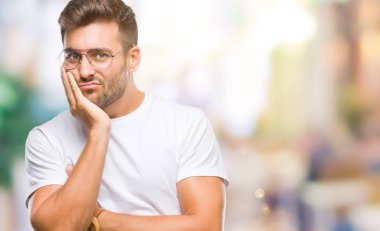 Seyir yorgun ve bıkkın ile depresyon sorun Çapraz kollar ile izole arka plan düşünme üzerinde gözlük takan genç yakışıklı adam.