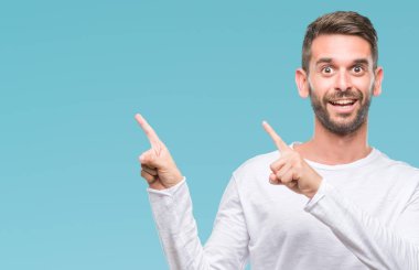 Yakışıklı delikanlı gülümseyen ve iki elleri ve parmakları ile tarafına işaret kamera bakarak izole arka plan üzerinde.