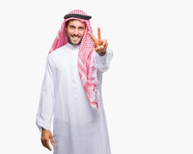 Keffiyeh zafer işareti yapıyor parmak gösterilen kamera seyir gülümseyen izole arka plan üzerinde giyen genç yakışıklı adam. İki numaralı.