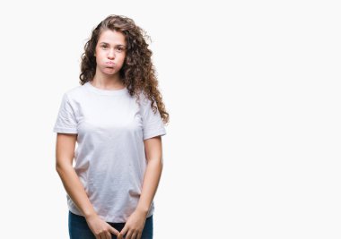 Güzel esmer kıvırcık saçlı Genç kız komik surat ile yanakları şişirme izole arka plan üzerinde rahat t-shirt giyiyor. Ağız ile hava, deli ifade şişirilmiş.