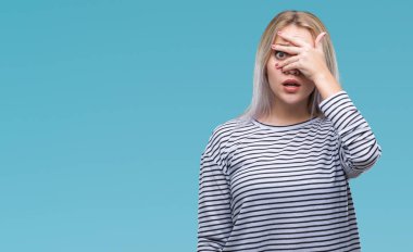 Mahcup ifadeyle parmaklarımın arasından seyir izole arka yüz ve gözler el ile kapsayan şok bakmak genç sarışın kadın.