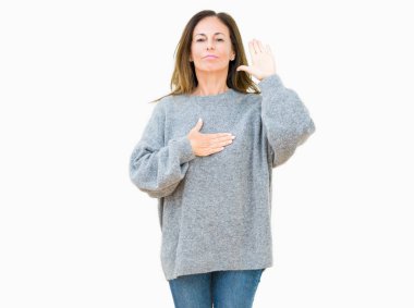 Üzerinde kış kazak giyen güzel orta yaş kadın izole arka plan göğüs ve bir sadakat sözü yemin yapma avuç, el ile küfür