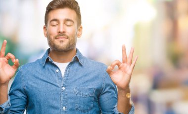 Yakışıklı delikanlı izole arka plan üzerinde dinlenmek ve gülümseyen gözlerle parmak ile meditasyon jest yapıyor kapalı. Yoga kavramı.