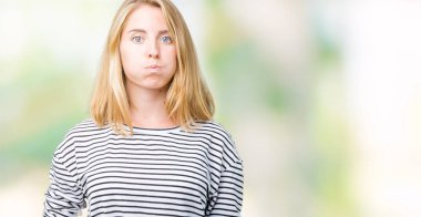 Komik surat ile yanakları şişirme izole arka plan üzerinde çizgili süveter giyen güzel genç kadın. Ağız ile hava, deli ifade şişirilmiş.