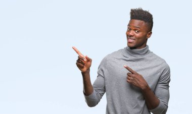 Gülümseyen ve iki elleri ve parmakları ile tarafına işaret kamera bakarak izole arka plan üzerinde genç Afro-Amerikan adam.