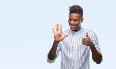 Gösterilen ve parmakları ile işaret izole arka plan üzerinde genç Afro-Amerikan adam kendinden emin ve mutlu gülümseyerek süre 6 numara.