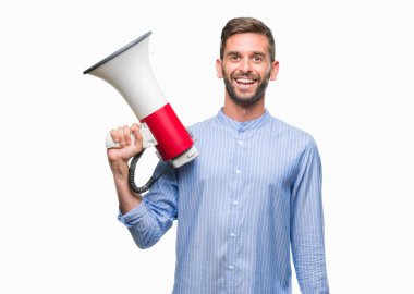 Yakışıklı delikanlı megafon ile izole arka plan üzerinde duran ve diş gösterilen kendine güvenen bir gülümsemeyle gülümseyerek mutlu bir yüz ile bağırıyor