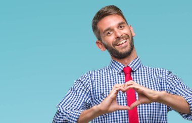 Genç yakışıklı iş adamı aşık kalp simgesi ve elleriyle şekil gösteren gülümseyen izole arka plan üzerinde. Romantik kavramı.