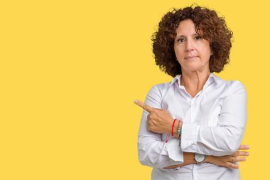 Güzel orta ager üst düzey businees kadın izole reklam, ciddi ve sakin yüz gösterilen yan el parmak ile işaret arka plan