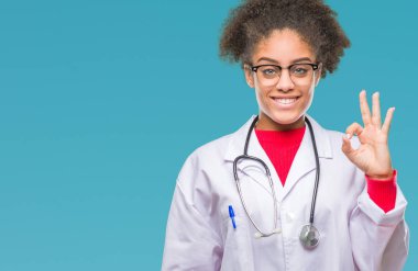 İzole arka plan el ve parmaklar ok işaretiyle yapıyor olumlu gülümseyen üzerinde genç afro Amerikalı doktor kadın. Başarılı ifade.