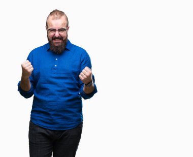 Üzerinde gözlük takan Genç beyaz hipster adam arka plan çok mutlu ve heyecanlı kaldırdı, silah ile kazanan jest yapıyor gülümseyen ve başarı için çığlık izole. Kutlama kavramı.