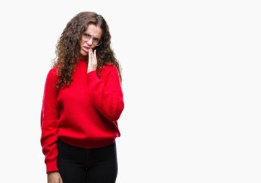 Güzel esmer kıvırcık saçlı Genç kız acı ifadesi ile el ile ağız diş ağrısı veya dişlerde dişlerle ilgili hastalık nedeniyle dokunmadan izole arka plan üzerinde gözlük ve kış kazak giyiyor. Diş hekimi kavramı.