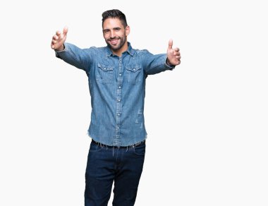 Yakışıklı delikanlı sarılmak için kollarını açarak gülümseyerek kameraya bakarak izole arka plan üzerinde. Neşeli ifade kucaklayan mutluluk.