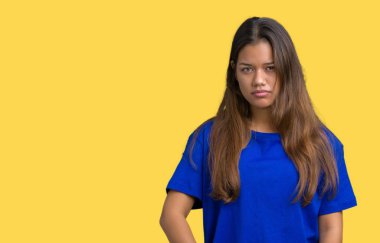 Çatık izole arka plan şüpheci ve gergin, mavi t-shirt giyen genç güzel esmer kadın sorunu nedeniyle üzgün. Negatif kişi.