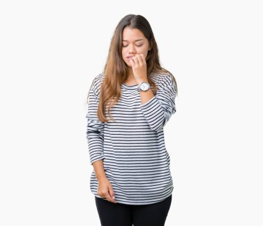 Stresli ve gergin elle çivi ısırma ağzına bakarak izole arka plan üzerinde çizgili süveter giyen genç güzel esmer kadın. Anksiyete sorunu.