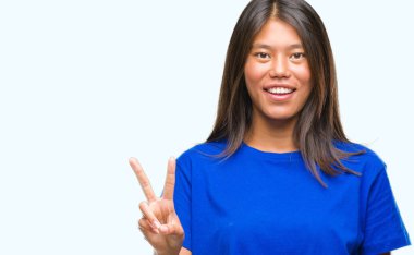 Genç Asyalı kadın gösterilen ve parmakları ile işaret izole arka plan üzerinde ikincisi ise kendinden emin ve mutlu gülümseyerek.