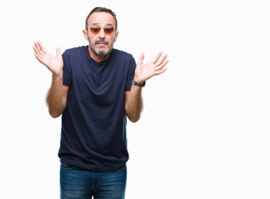 Orta yaş ağarmış komuta sizde izole arka plan clueless ve şaşkın bir ifadeyle kollar ve eller kaldırdı üzerinde güneş gözlüğü takıyor. Şüphe kavramı.
