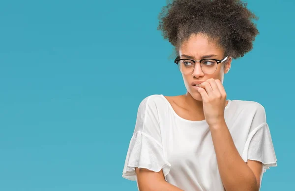 年轻的美国黑人妇女戴着眼镜在孤立的背景下 看着压力和紧张的嘴咬指甲的手 焦虑问题 — 图库照片