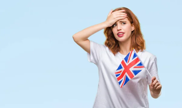 年轻美丽的妇女持有英国国旗在孤立的背景下强调与手在头上 震惊与耻辱和惊喜的脸 愤怒和沮丧 对错误的恐惧和不安 — 图库照片