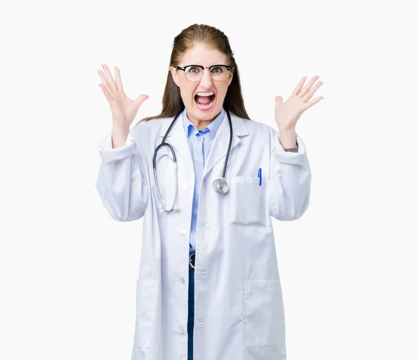 中年成熟的医生妇女穿着医疗外套在孤立的背景庆祝疯狂和惊讶的成功与手臂抬起和睁开眼睛尖叫兴奋 优胜者概念 — 图库照片