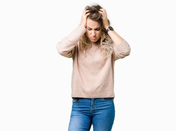 美丽的年轻金发碧眼的女人穿着运动衫在孤立的背景下遭受头痛绝望和压力 因为疼痛和偏头痛 双手放在头上 — 图库照片