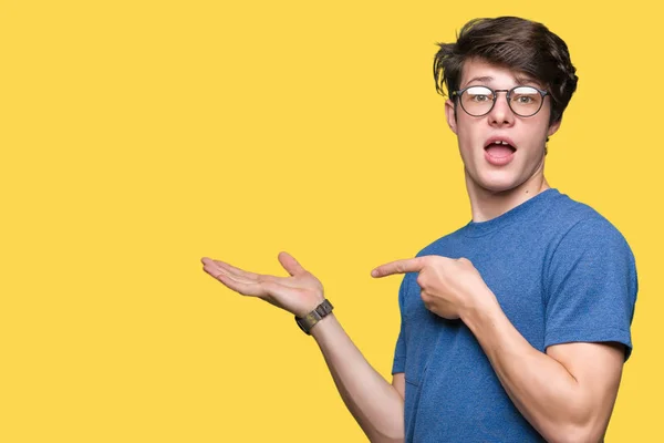 Jovem Homem Bonito Vestindo Óculos Sobre Fundo Isolado Espantado Sorrindo — Fotografia de Stock